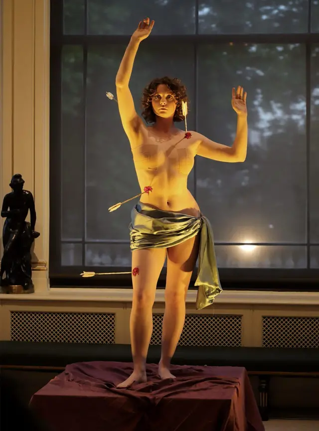 La artista Holly James haciendo la performance de escultura viviente.