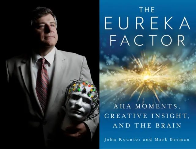 John Kounious con traje beige y corbata a rayas en tonos azules y naranja, mirando hacia la derecha y sosteniendo una cabeza de maniquí con electrodos de colores. Al lado, portada del libro Eureka Factor que es azul y en el medio tiene un estallido representado con una estrella brillante y grande