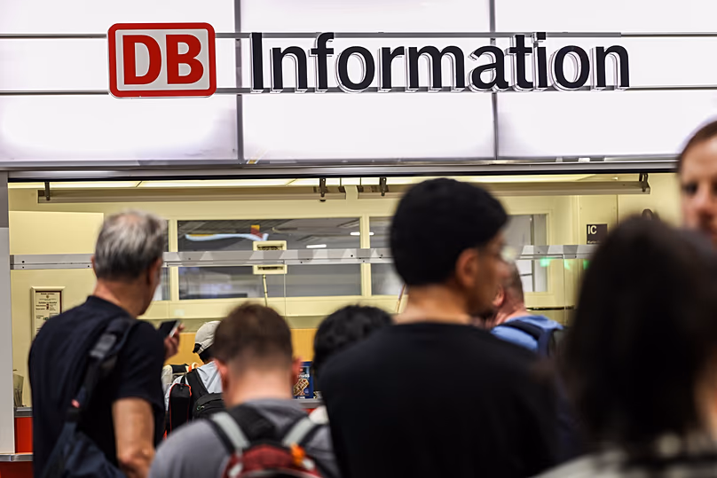 Passengers line up at the DB information desk at the Duisburg train station, Tuesday, June 23, 2026