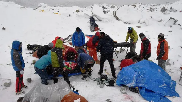Sherpas y otros escaladores intentan ayudar a un herido después de que una avalancha provocada por un terremoto azotara partes del campamento base del Everest en 2015.