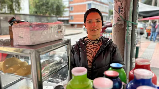 Paola detrás de su puesto de trabajo, en el que hay una vitrina con empanadas.