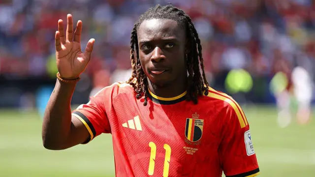 Jeremy Doku saluda a los seguidores vestido con la camiseta de Bélgica.