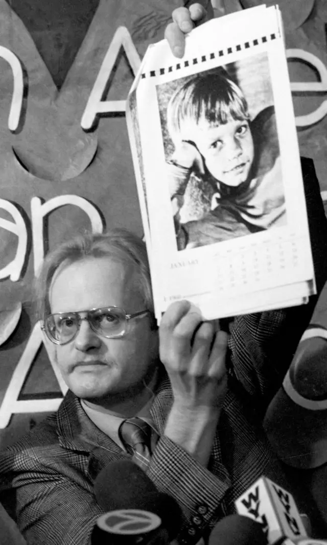 Un hombre sostiene un calendario con la cara de Etan (foto a blanco y negro).