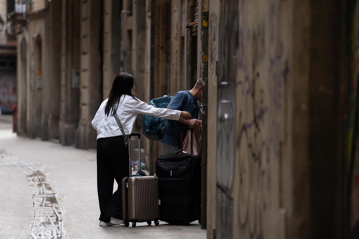 Dos personas accediendo a un piso turístico. (Europa Press)