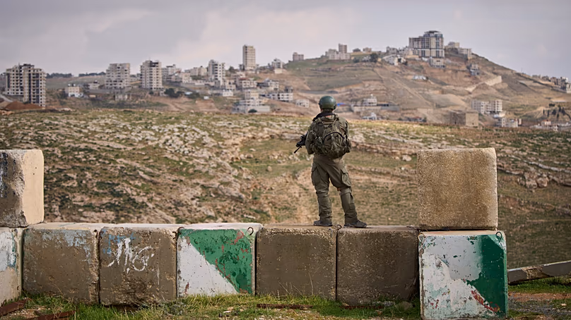 An Israeli soldier stands guard during the inauguration ceremony for the newly legalized Jewish settlement of Yatziv. (AP Photo/Ohad Zwigenberg)