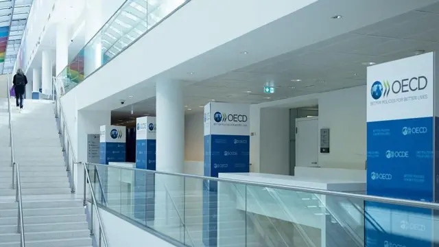 Fachada de edificio con carteles de la OCDE.