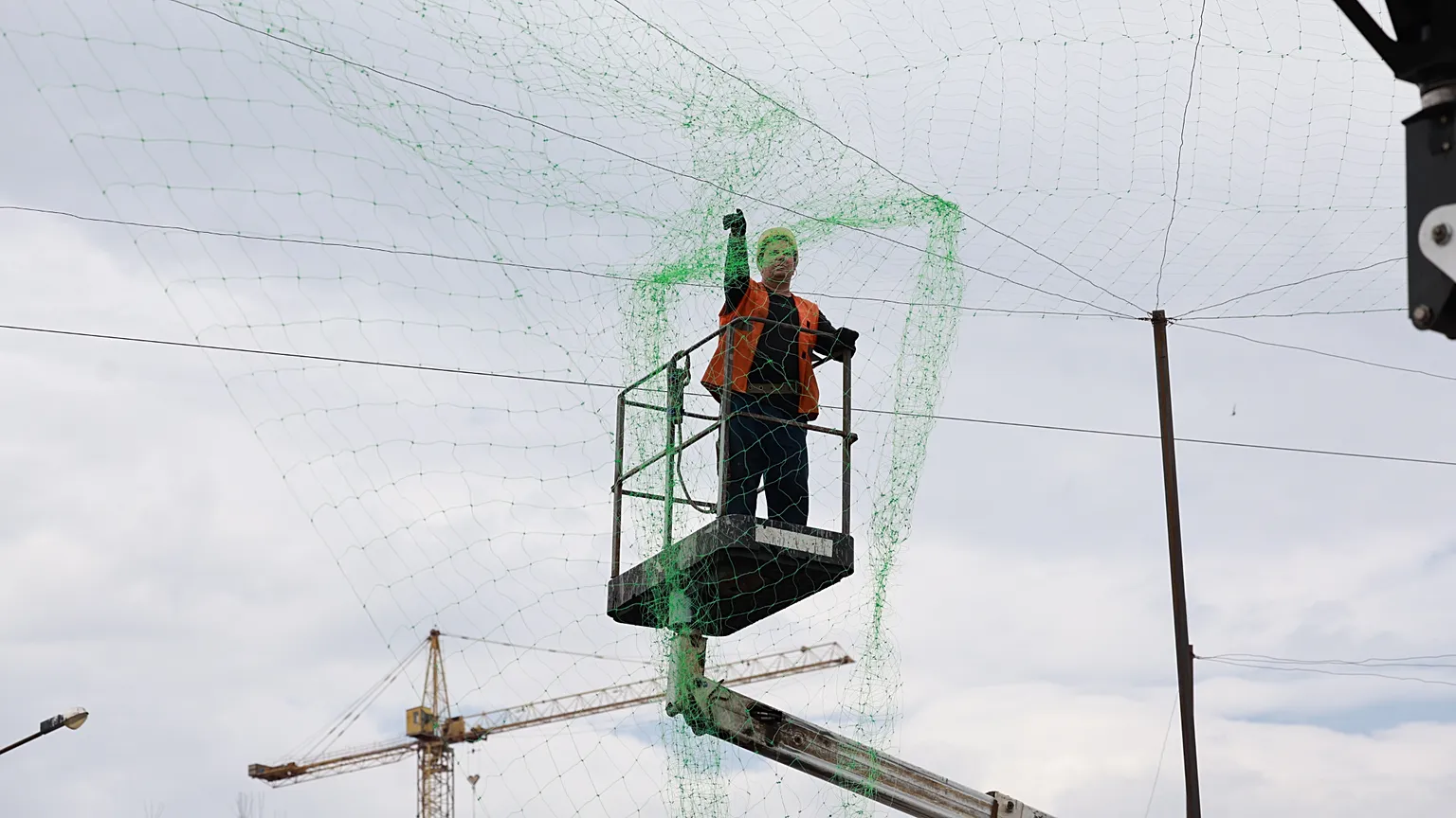 A municipal worker installs anti drone net to prevent Russian attacks on people and transport in Zaporizhzhia, Ukraine, Thursday, June 18, 2026.