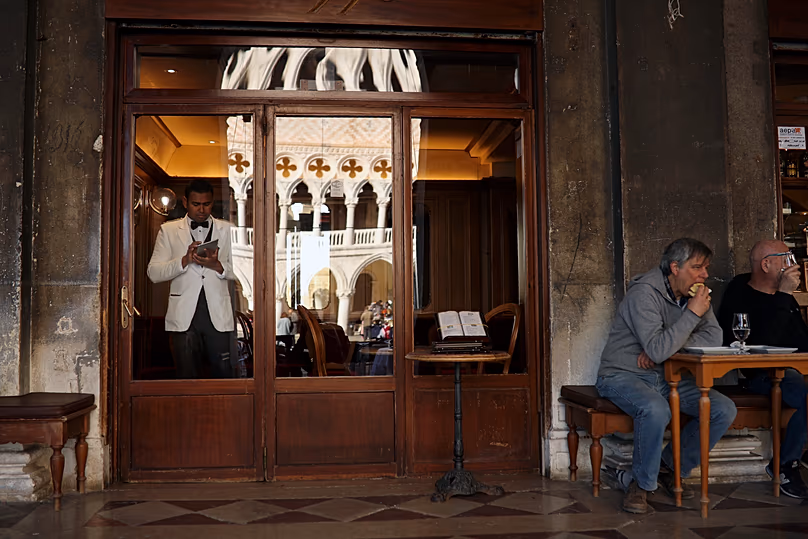 People having a meal at a restaurant in St. Mark's Square, Venice, Italy