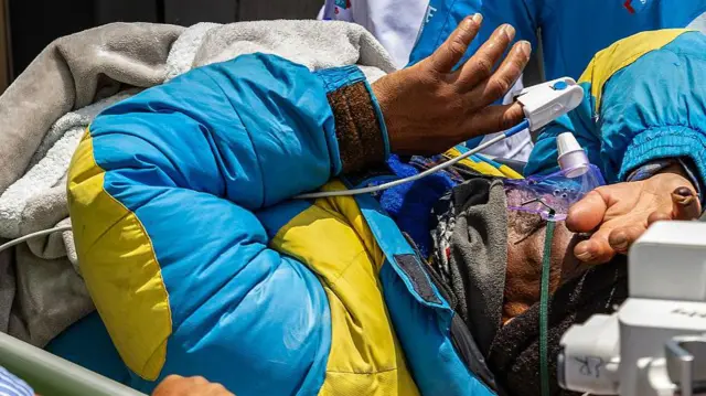 Dawa Sherpa en el momento en que es llevado en camilla al hospital de Katmandú