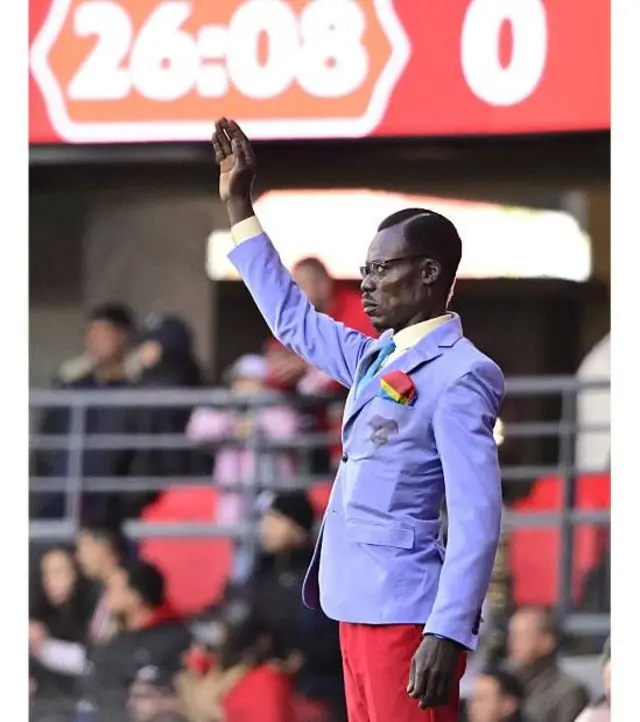 Lumumba Vea parado en pose de estatua durante un partido de la Copa de Naciones Africana en 2025