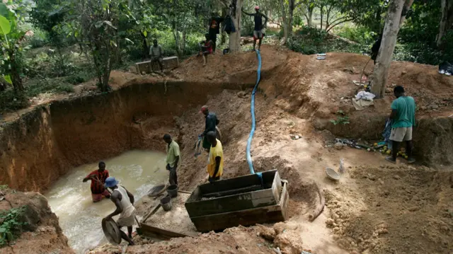 Una mina de diamantes informal en Sierra Leona, donde unos hombres tamizan en busca de gemas en un gran estanque,