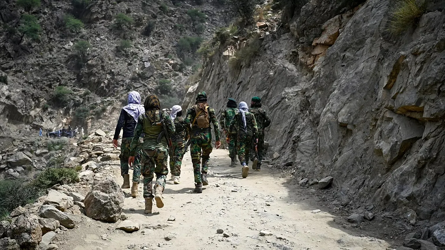 Taliban soldiers walk along a dirt road in eastern Kunar province, 2 September, 2025