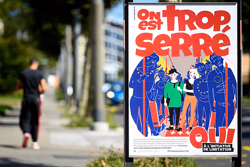 A poster of the Swiss People's Party (SVP) for a moderate immigration initiative reading 'we're too tight!' in Lausanne, 8 September, 2020