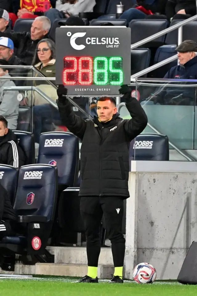 El cuarto árbitro Lorenzo Hernández, vestido de negro, levanta un cartel electrónico que indica una sustitución durante la primera mitad de un partido de la MLS el 7 de marzo de 2026 en St. Louis, Missouri.
