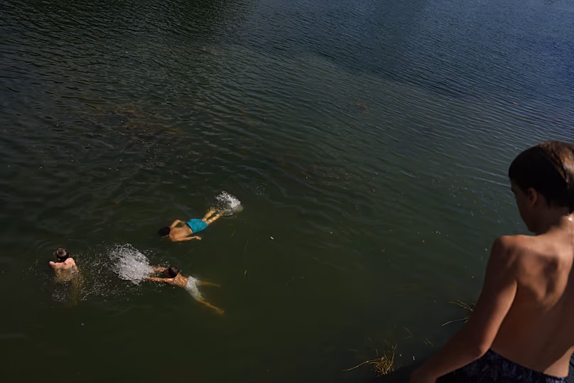 Young boys swim in the Seine in Samois-sur-Seine, south of Paris, on 19 June 2026