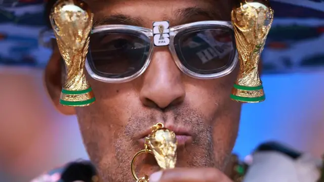 Fan con lentes de copas del Mundo besa una copa del Mundo en llavero