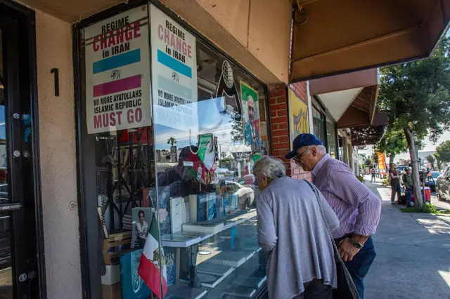 Una pareja mira los libros en la sala de exhibición de una librería iraní con carteles contra los ayatolás en la Plaza Persia del vecindario West LA en Los Ángeles, California, el 28 de febrero de 2026. (Foto de Apu GOMES / AFP vía Getty Images)