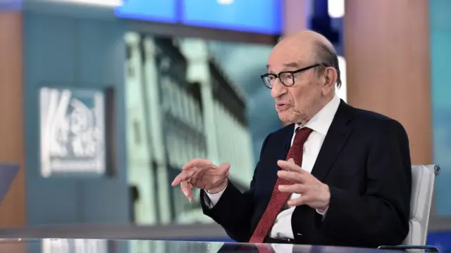 Alan Greenspan concediendo una entrevista en 2018. Está sentado en el plató de un programa de televisión y explica algo a un entrevistador que no aparece en imagen.