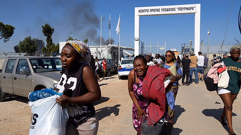 Female migrants exit the Pournara migrant reception center. Oct. 28, 2022. (AP Photo/Petros Karadjias, File)