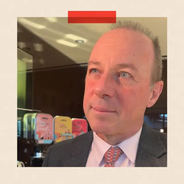 Foto de la cara de Giuseppe Lavazza en primer plano, y en el fondo se ve que está en una de sus cafeterías