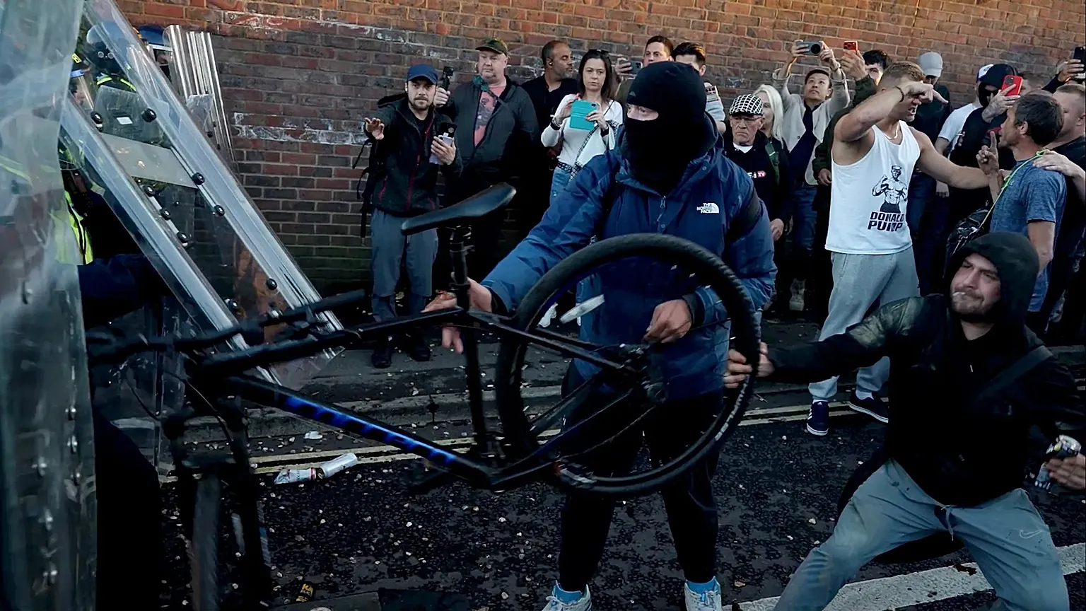 In this image taken from PA Video, police and protestors clash during a protest following the death of Henry Nowak, a 18-year-old student stabbed to death.