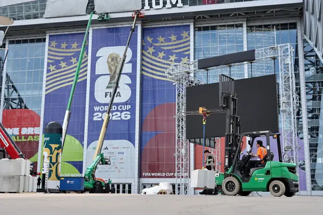 Obreros colocan carteles en un estadio de la Copa del Mundo en EE.UU.