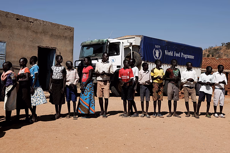 Children wait in line to receive aid from the World Food Programme in Kauda, 9 January, 2020