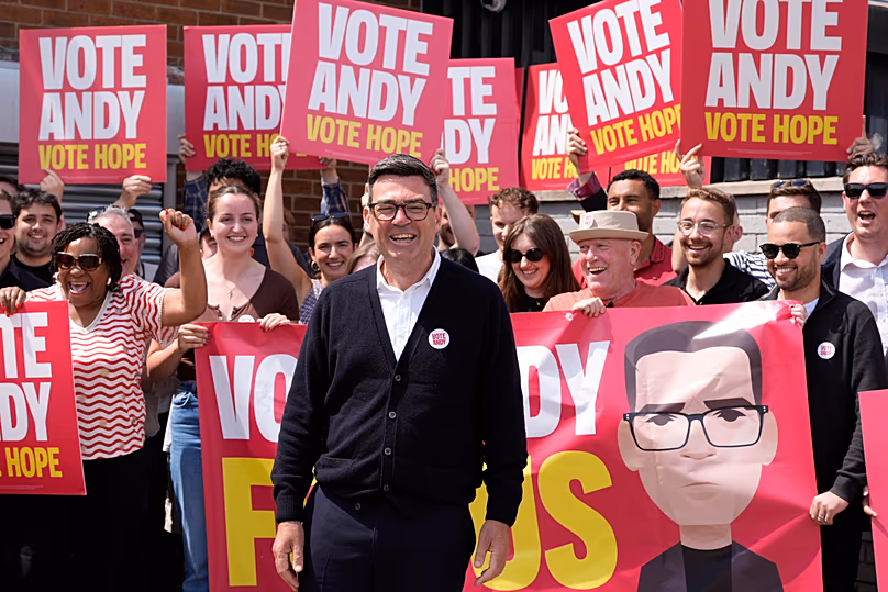 Burnham poses for a photo, surrounded by supporters at the Stubshaw Cross Community and Sports Club.