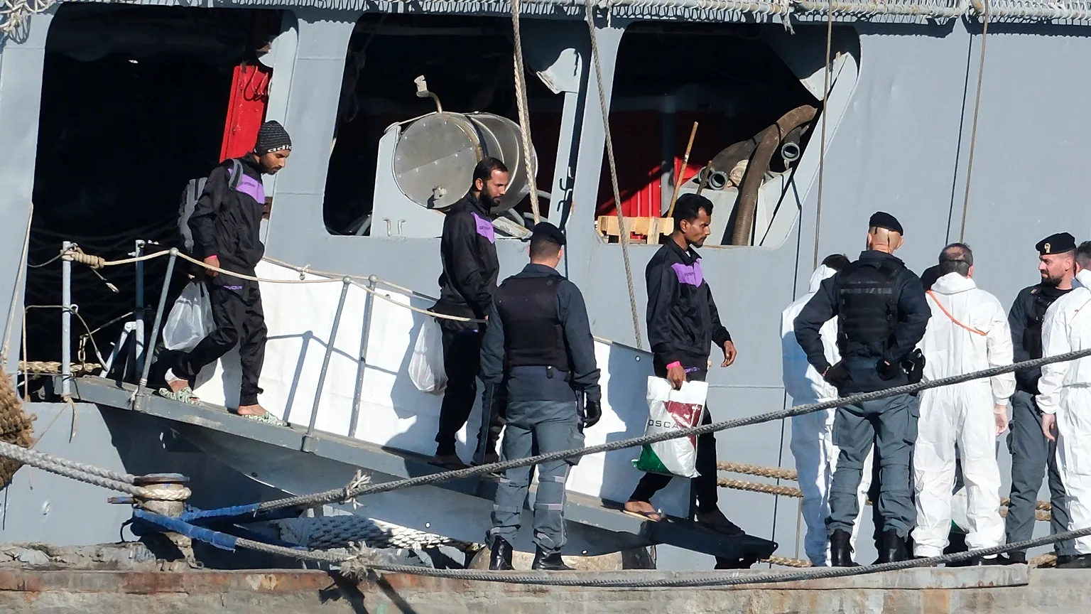 Migrants disembark from the Italian navy ship Libra at the port of Shengjin, where Italy set up a center similar to a return hub