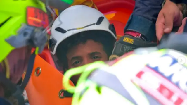 Se ve la cara de un niño, rodeado de equipamiento de rescate