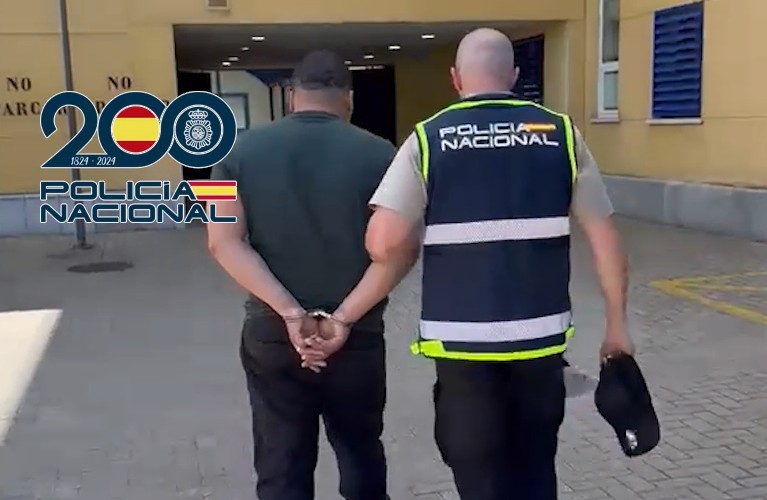 Un agente de la Policía Nacional traslada a uno de los detenidos.