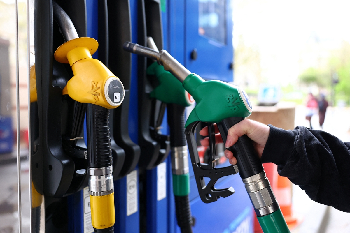 Una mujer sostiene el surtidor de gasolina. REUTERS/Abdul Saboor