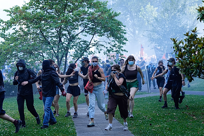 Protesters disperse through a grassy area during a "No G7" demonstration in Geneva, Switzerland, Sunday, June 14, 2026, ahead of the G7 summit scheduled to take place June 15-