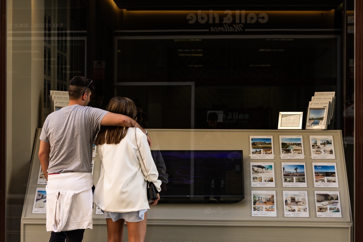 Dos jóvenes miran los anuncios de viviendas en venta en una inmobiliaria.Tomàs Moyà / Europa Press