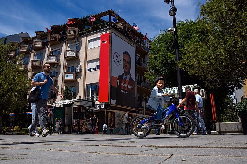 People walk past a giant election poster of acting prime minister Albin Kurti in Pristina, 5 June, 2026