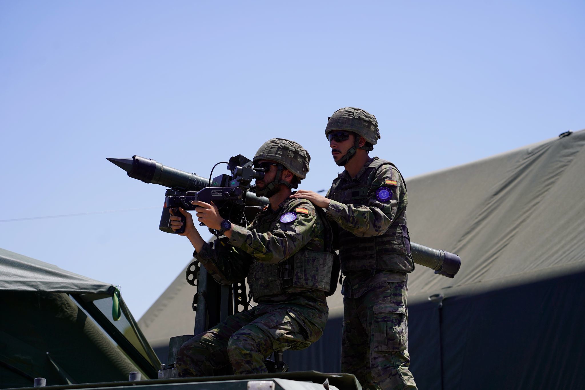 Militares sobre un vehículo preparados para disparar
