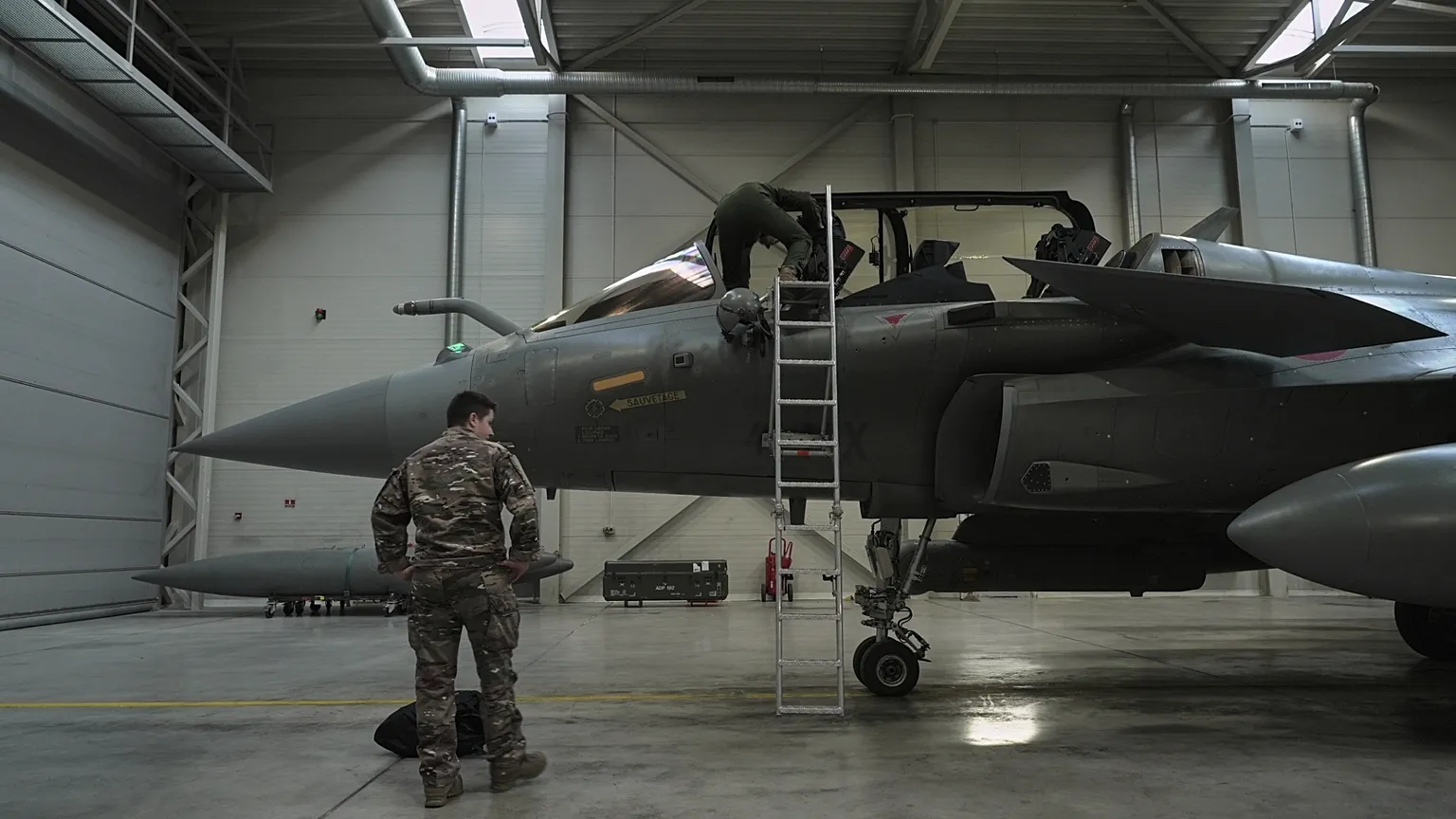 A flight-crew member climbs into the cockpit of a French air force Rafale fighter jet stationed on a NATO air-policing mission at the Siauliai Air Base in Lithuania.