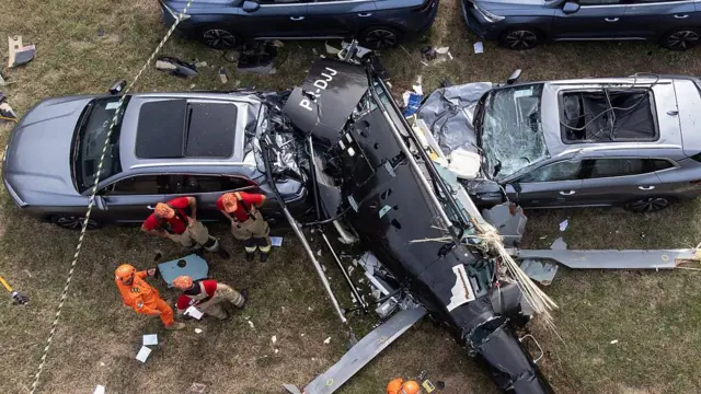 Una vista aérea muestra a bomberos trabajando en el lugar donde se estrelló un helicóptero en el barrio de Recreio dos Bandeirantes, en Río de Janeiro, el 14 de junio de 2026.