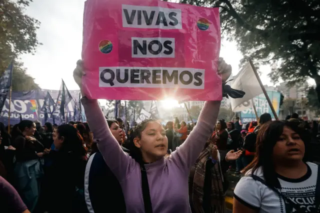 Una chica sostiene un cartel en el que dice "Vivas nos queremos" en una manifestación.