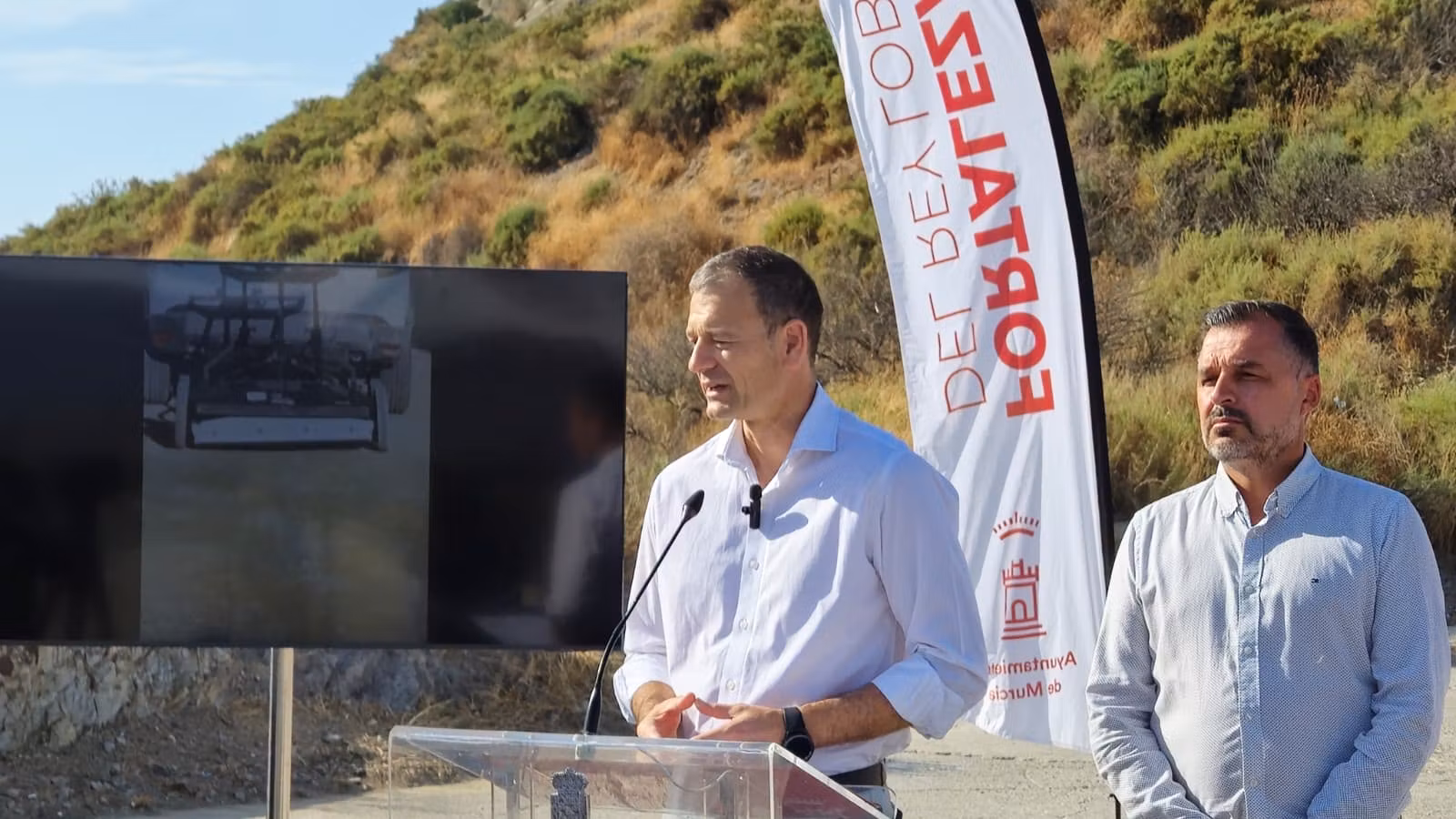 El presidente presenta el georradar en el acto celebrado junto a la ladera, acompañado por representantes municipales.