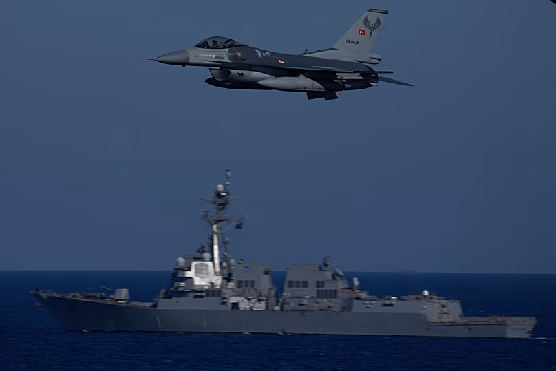 A Turkish F16 fighting jet flies over naval ships during an annual NATO naval exercise in the Mediterranean, 15 September, 2022