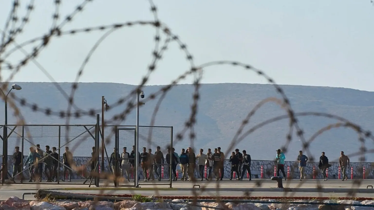 FILE - Migrants rescued south of Crete walk after their arrival at the the port of Lavrio, Greece, on July 10, 2025