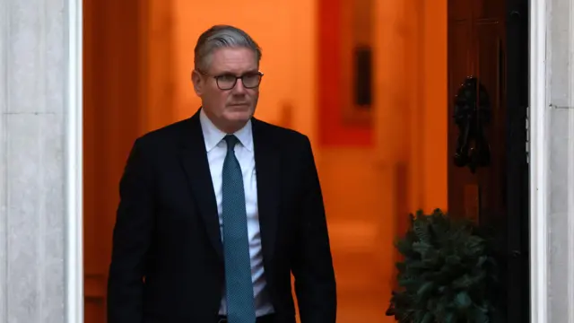 El primer ministro del Reino Unido, Keir Starmer, sale por una puerta.