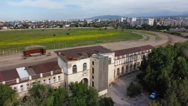 El edificio y la pista del hipódromo con la ciudad de fondo