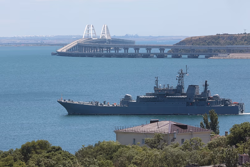 FILE - A Russian military landing ship transports cars and people because the Kerch Bridge connecting the Russian mainland with the Crimean Peninsula over the Kerch Strait 