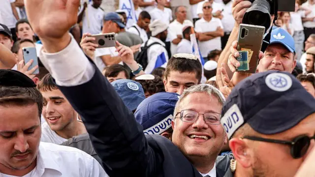 Itamar Ben Gvir, rodeado de policías israelíes, saluda con la mano a otros activistas de extrema derecha reunidos frente a la Puerta de Damasco, en la Ciudad Vieja amurallada de Jerusalén, en mayo de 2025.