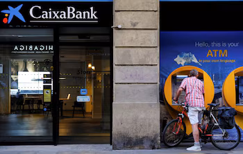 Un hombre utiliza un cajero automático de CaixaBank en Barcelona. REUTERS/Nacho Doce