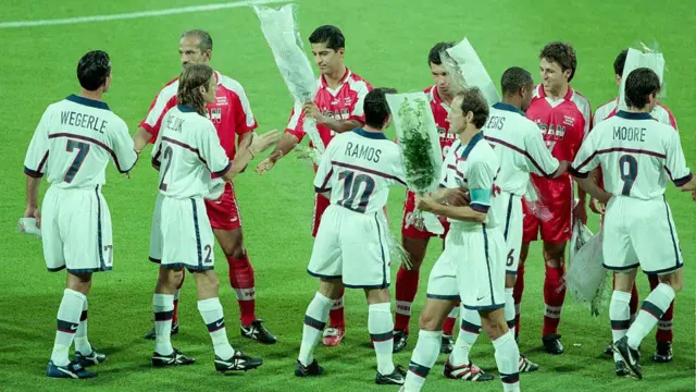 De izquierda a derecha: Frankie Hejduk, Tab Ramos, Joe Max Moore, David Regis, Kasey Keller y Thomas Dooley, de Estados Unidos, intercambian flores con el equipo iraní antes del partido de la primera ronda de la Copa Mundial entre Estados Unidos (1) e Irán (2) en el Stade de Garland el 21 de junio de 1998 en Lyon, Francia.