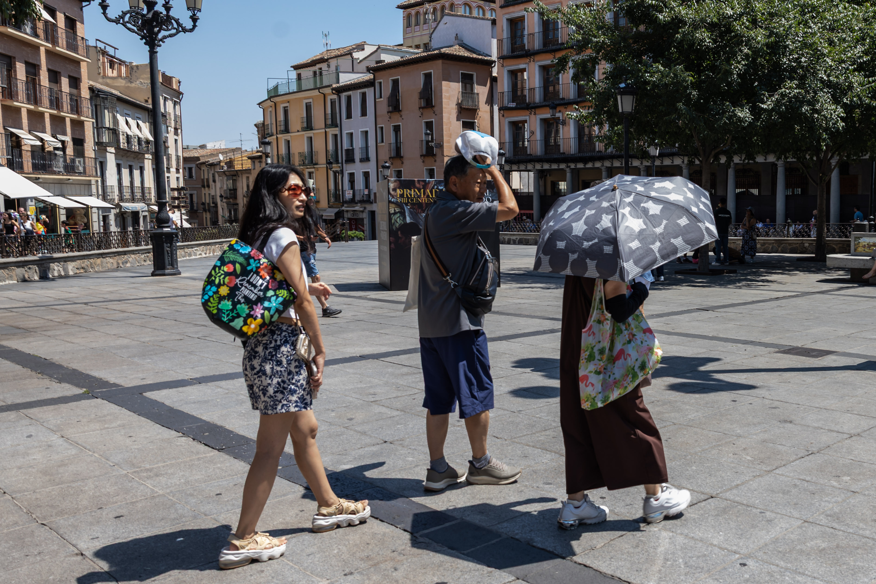 Turistas se protegen del calor este domingo en Toledo.