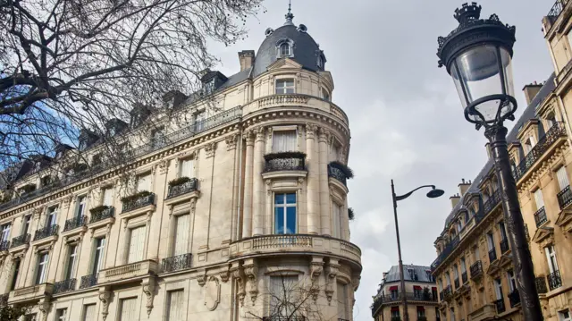 Vista exterior del edificio en la Avenida Foch donde se encontraba el apartamento de Epstein, que muestra un imponente edificio de piedra con una cúpula en la esquina.